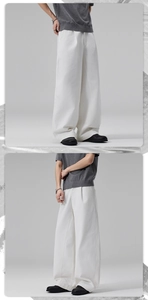 Detail view of white wide-leg cotton pants featuring a double pleated loose fit design