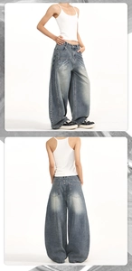 Dettaglio dei jeans baggy blu slavato a gamba larga con ricamo della lettera H sulla tasca