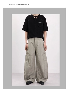 Détail du pantalon cargo avec coutures genoux et t-shirt noir à encolure ajourée
