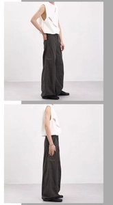 Detail of dark grey wide-leg cargo pants and white mesh vest on a male model
