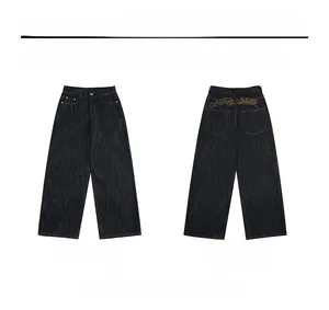 Detail view of brown artistic embroidery on dark blue vintage straight-leg denim jeans