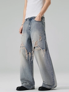 Men's light blue distressed wide leg denim jeans with heavy ripped street style details