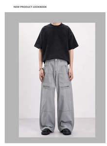 Detail of vintage gray cargo pants with oversized zipper pockets and layered stitching