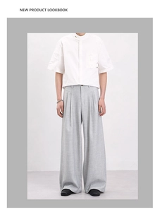 Detail of light grey textured wide-leg trousers with elegant drape in minimalist urban style