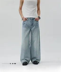 Dettaglio dei jeans in denim azzurro dal taglio dritto e largo con effetto sbiadito