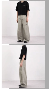Détail du pantalon cargo montrant la poche zippée latérale et la coupe large ample