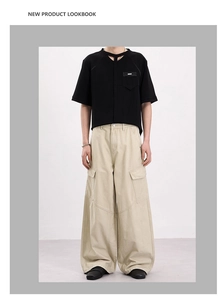 Dettaglio della t-shirt nera con intaglio sul collo e pantaloni cargo kaki con grandi tasche