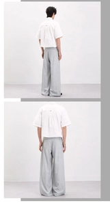 Rear view of white minimalist short-sleeve shirt and grey loose drape pants on model
