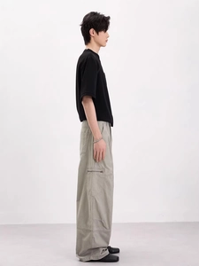Tenue rétro pour homme avec t-shirt noir et pantalon cargo large en vert-gris clair