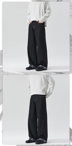 Detail of high street black wide leg jeans featuring contrast stitching and plaid hem lining