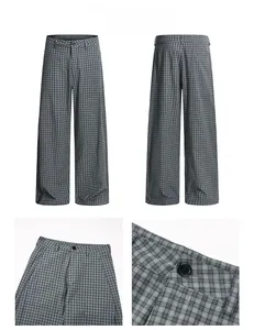 Close-up of high-waist pleated plaid trousers with button and zipper details