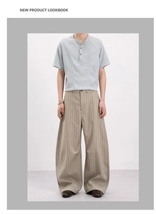 Détail d'un pantalon rayé kaki à jambe large et d'un t-shirt Henley gris pour homme