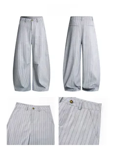 Détails du pantalon large gris à rayures montrant la taille boutonnée et la coupe