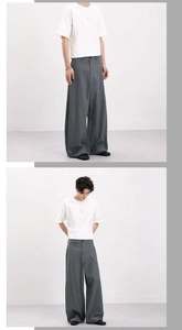 Detail view of grey plaid wide-leg trousers showing drape texture and relaxed fit style