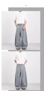 Détail montrant la texture à rayures verticales et le drapé fluide de ce pantalon large homme