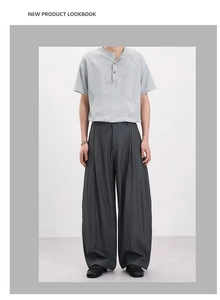 Close-up of deep grey striped wide-leg trousers with high-quality drape and texture