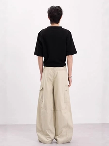 Pantaloni cargo larghi stile retrò da uomo con grandi tasche e maglietta nera vista posteriore
