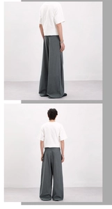 Detail view of baggy plaid trousers with wide leg cut and elegant drape in minimalist style