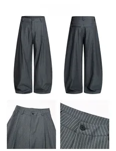 Detail view of dark grey pinstripe trousers showing double pleats and tailored waist texture