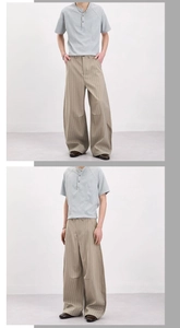 Détail d'un t-shirt Henley gris et d'un pantalon large à rayures kaki sur un mannequin