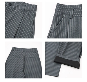 Detail view of grey pinstripe suit trousers showing waist closure and hem stitching