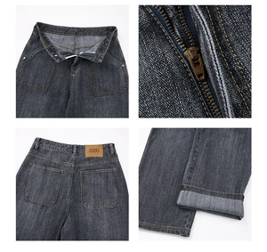 Detailansicht grauer Jeans mit YKK-Reißverschluss und braunem Lederetikett am Bund