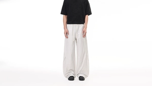 Detailed view of light gray cargo pants featuring an elastic drawstring waistband and textures
