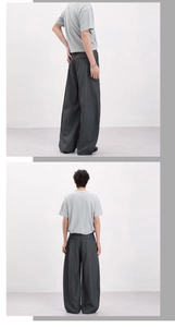 Detailed views of dark grey pinstripe wide-leg trousers with soft draped fabric for men