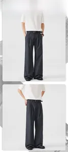 Detail of pleated dark grey wide-leg trousers with elegant drape and black leather belt