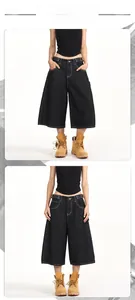 Detail of dark wash carpenter denim shorts with white contrast stitching and wide leg cut