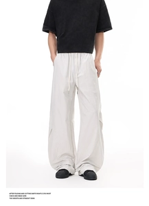 Detail of light gray wide-leg cargo pants featuring an elastic drawstring waistband