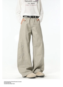 Detail of khaki wide-leg cargo pants with high waist, black belt, and stitched side pockets