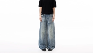 Detail of vintage washed light blue denim with whiskers and wide leg high street fit
