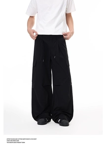 Detailed view of black wide-leg cargo pants with large flap pockets and drawstring waist