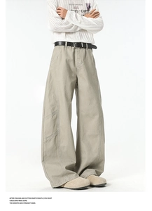 Detail of khaki wide-leg cargo pants with utility pockets and a black pin buckle belt