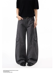 Detail of dark grey wide-leg cargo pants with large flap pockets and street style design