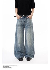 Close-up detail of vintage wash denim jeans with cat whiskers and oval buckle belt