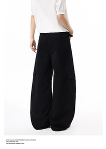 Detailed side view of black wide-leg cargo pants with large side pockets and flap pockets