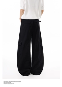 Detail of multi-pocket cargo pants showing wide-leg cut and premium fabric texture