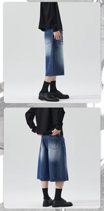 Detail of loose fit dark blue denim shorts with washed distressed texture and back pocket