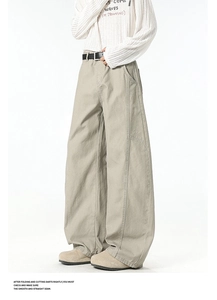 Detail of light khaki wide-leg cargo pants with stitching and black pin buckle belt