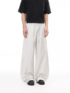 Men's loose parachute cargo pants in beige with drawstring waist and knee pleats