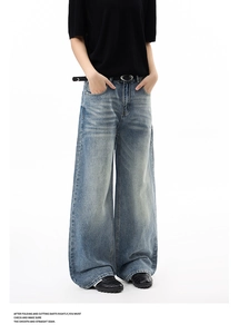 Detail shot of vintage washed high-waist wide-leg jeans with cat-whisker fading and belt