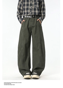 Detail of dark olive green cargo pants featuring structural stitching and side utility pockets