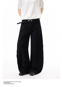 Detailed close-up of black wide-leg cargo pants featuring side flap pockets and a silver buckle belt