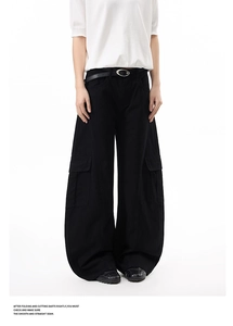 Detail of black wide-leg cargo pants with metallic buckle belt and large flap pockets