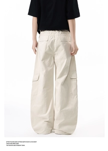 Rear view of oversized cream cargo pants with multiple functional flap pockets