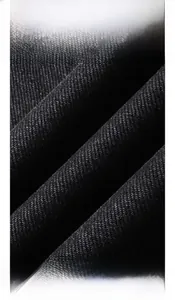 Vue macro de la texture du tissu denim sergé noir avec tissage diagonal bien visible
