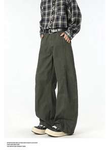 Detail view of dark green cargo pants featuring vintage vertical stitching and wide leg cut