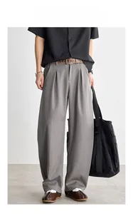 Détail du pantalon gris homme à jambe large incurvée avec plis à la taille et texture